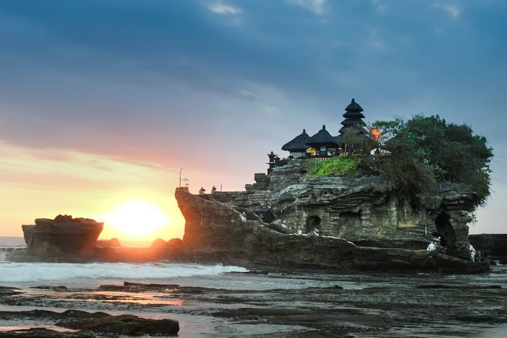 A tengerbe nyúló sziklán álló Tanah Lot templom naplementében, Bali
